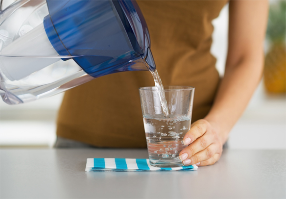 woman pouring filtered water into a glass